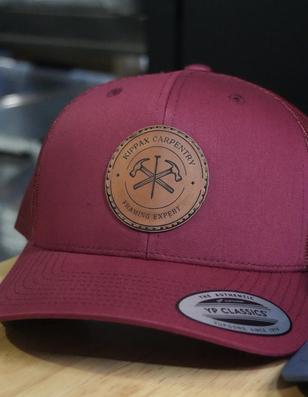 Kippax Carpentry trucker hat maroon leather patch